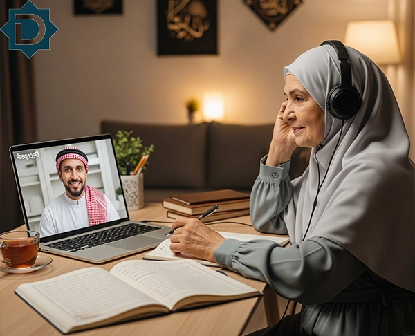An elderly woman in a hijab and headphones attentively participating in an Hadith Course Online class on her laptop, with a male instructor on screen and an open book and notebook on her desk.