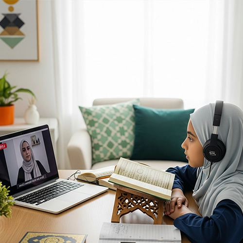 A young girl in a grey hijab and headphones attentively participating in an online Madni Qaida Course Online lesson on a laptop, with a physical Quran open on a wooden stand.